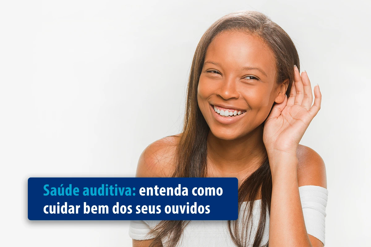 Mulher sorridente com uma das mãos ao lado do ouvido. Título do texto é saúde auditiva: entenda como cuidar bem dos seus ouvidos