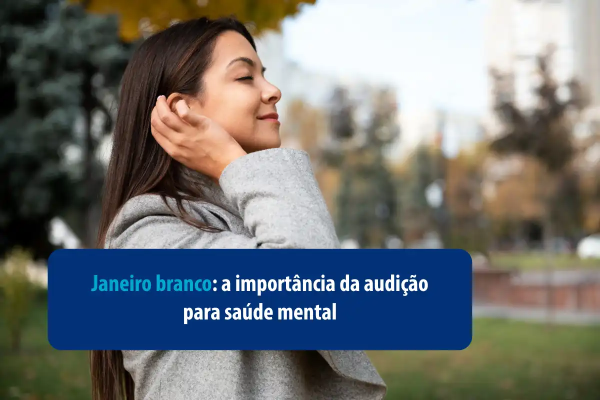 Mulher sorrindo em um ambiente ao ar livre. Janeiro Branco: a importância da audição para a saúde mental.