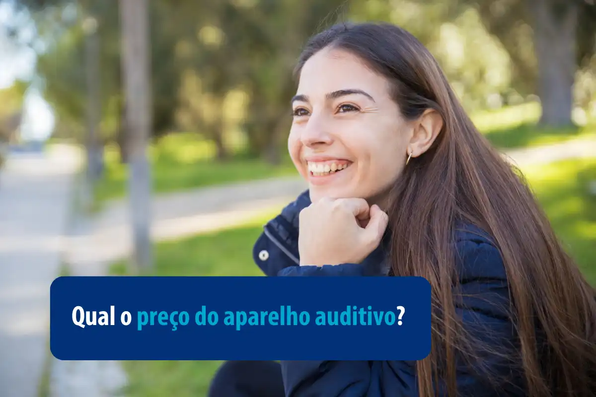 Mulher sorrindo ao ar livre com um fundo verde, refletindo sobre o preço do aparelho auditivo em um ambiente tranquilo.